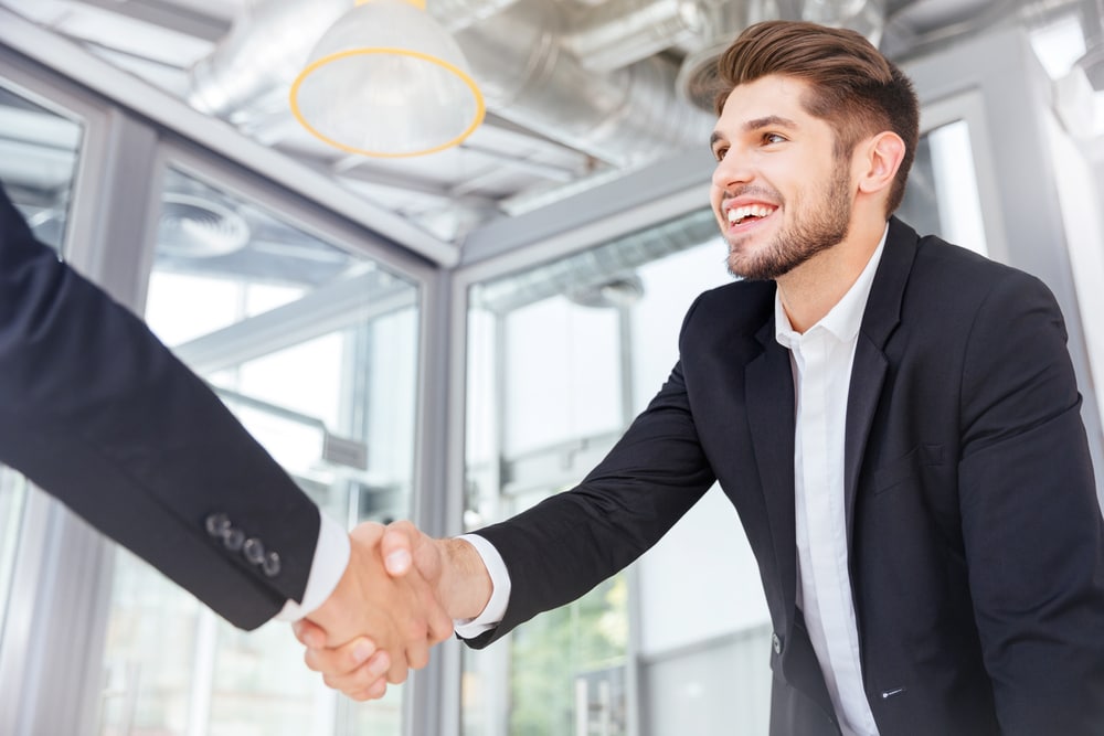 Two,Smiling,Successful,Young,Businessmen,Shaking,Hands,On,Business,Meeting